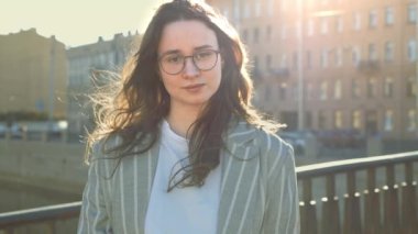 Genç bir kadın kameraya bakar ve gülümser.