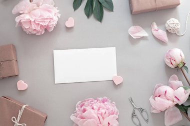 Pembe şakayık çiçekleri, hediyeler, makas, ortasında boş beyaz çarşaf, üst ve düz döşeme, çiçek çerçevesi, kopyalama alanı