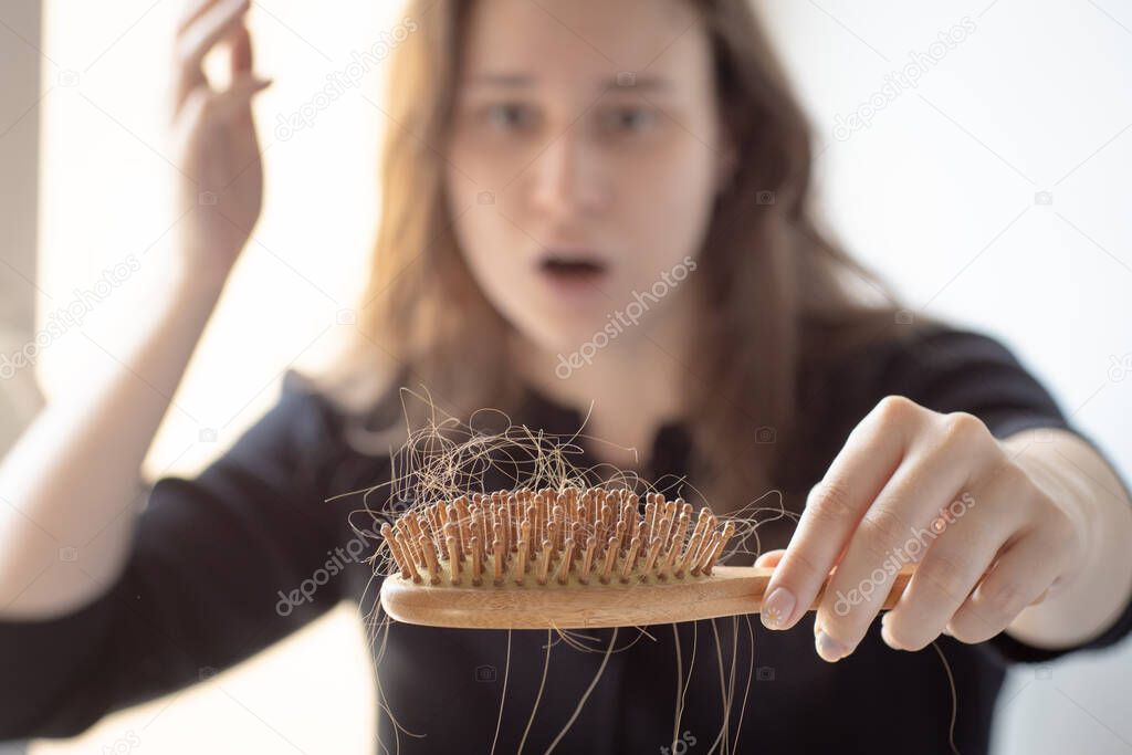 hair loss on the comb, massage wooden brush with a clump of hair, problem of growth, hair loss and hair care