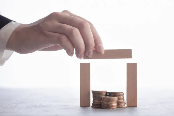 Mão Dobra Uma Casa Madeira Feita Blocos Com Moedas Interior — Fotografia de Stock