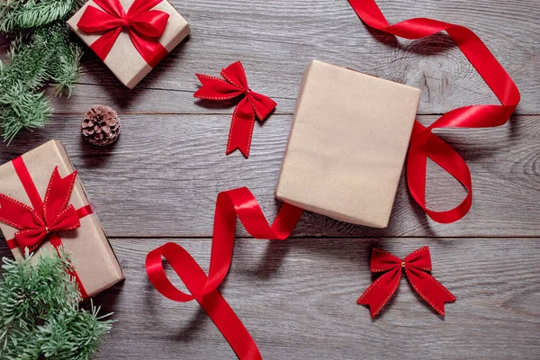 Weihnachtsdesign Mit Geschenken Auf Holztisch Tannenzweigen Zapfen Roten Schleifen Und — Stockfoto