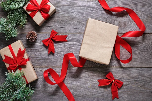 Tahta Bir Masaya Noel Hediyelerini Işi Kağıtlarını Kırmızı Kurdeleyi Boş — Stok fotoğraf