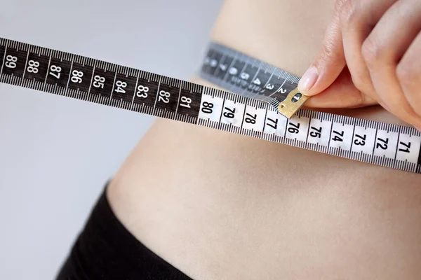 若い女性は体重減少のための測定テープ 美しい図 スポーツ マッサージや食事で腰を測定します — ストック写真