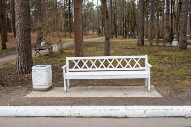 Parktaki beyaz bank ve çöp tenekesi