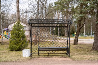 Parktaki siyah ahşap, metal bank ve çöp tenekesi