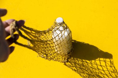 Yeniden kullanılabilir eko ipli bir alışveriş poşetinde, sert gölgeli cam bir süt şişesi. Eski tarz alışveriş için modern yeniden kullanılabilir çanta, çevre dostu plastik ücretsiz konsept, sıfır atık konsept, üst görünüm