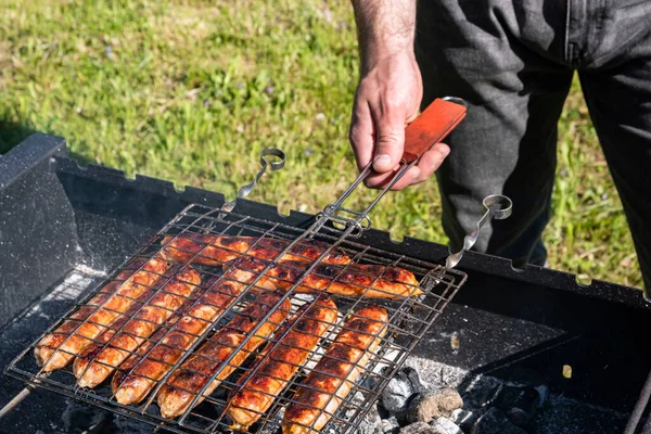 Man Cooks Sausages Grill Charcoal Grill Summer Picnic Nature Barbecue — Stock Photo, Image