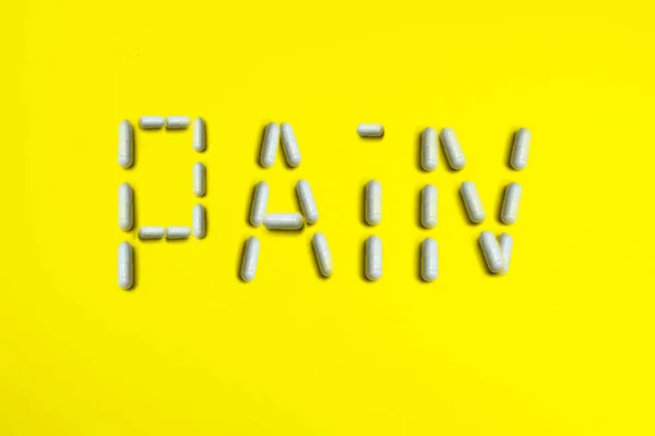Haplar Sarı Arka Planda Pain Kelimesini Kapsüller Tıbbi Tıp Konsepti — Stok fotoğraf