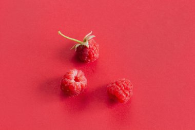 Olgun organik ahududu meyveleri, sağlıklı yaz meyveleri. Pembe arkaplanda kırmızı ahududu deseni düz..