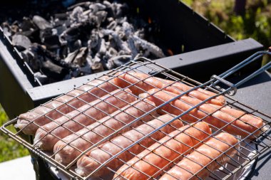 Kömür ızgarasında çiğ sosis, doğada yaz pikniği, barbekü bbq ızgara geleneksel Alman sucuklu sosisi. 