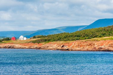 Cape Breton sahilindeki çiftlik evi ve kırmızı ahır, Nova Scotia, Kanada