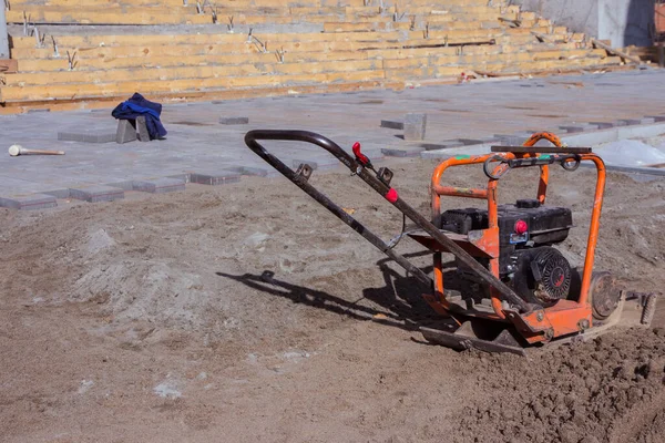 Vibrating plate compactor machine at a construction site. Equipment for soil thrombosis. Compaction work on sand, earth or asphalt