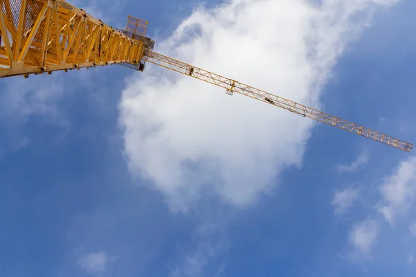 Tower construction crane against the blue sky. Big Yellow Construction Crane