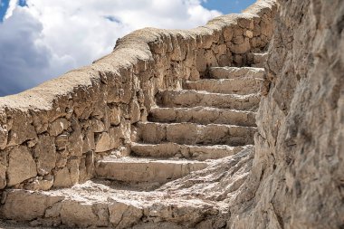 Dağdaki taş merdiven. Bulutlara ve gökyüzüne karşı. Aşağıdan yukarıya bak.