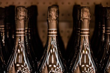 The necks of champagne bottles. Against a dark background. On the bottles of reflection lamps. Soft focus. Blurred background.