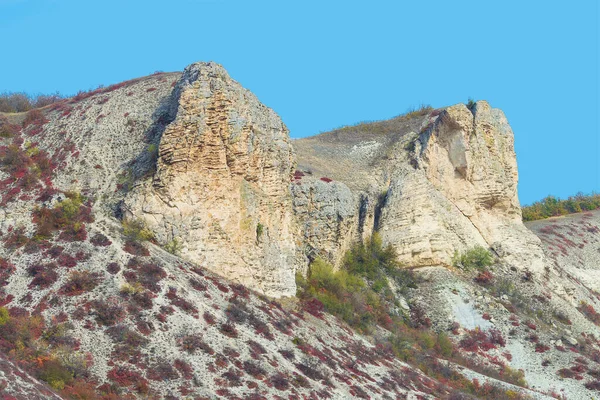 Two chalk cliffs. The Crimean landscape against the sky is cloudless. View from below.
