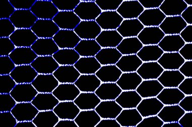 Metal ızgara altıgen renktedir. Siyah bir arkaplanda ışığın önünden görüntüle.