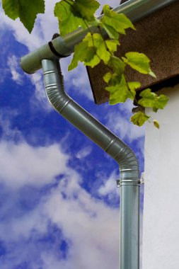 Çatıdan drenaj borusu. Güneşli bir yaz gününde ön manzara.