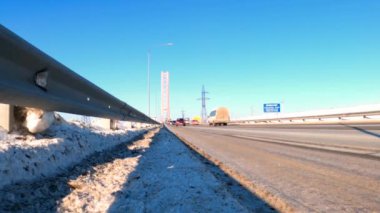 Ob Nehri üzerindeki köprüde arabalar sürüyor. Kamera asfaltta, aşağıda. Kış. Surgut, Rusya, Mart 01, 2021.