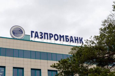 Modern binanın çatısındaki Gazprombank tabelası ve logosu. Surgut, Rusya - 17 Mayıs 2021.