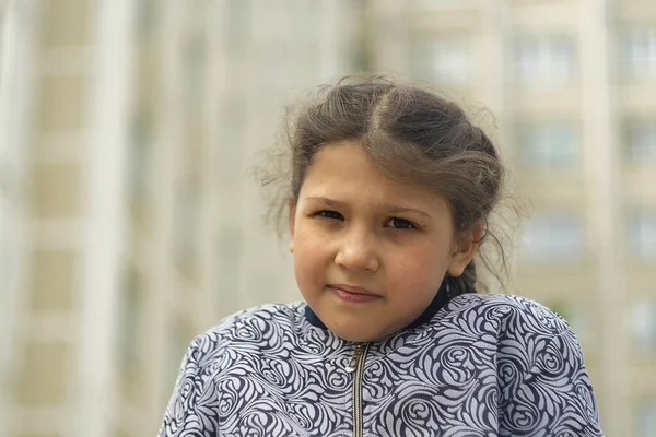 8 yaşındaki bir kız binalara karşı. Gün, yatay çekim Ön görüntü.