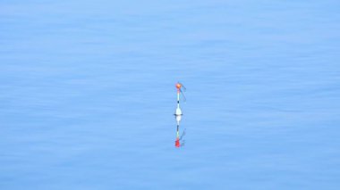 Balıkçı oltası gölde yüzer.