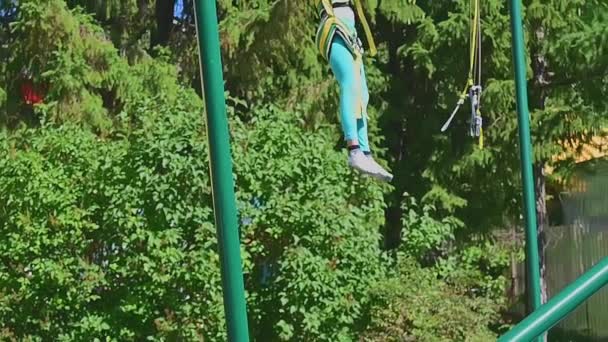 Lastik Bantlarla Bağlanmış Bir Kız Trambolinde Zıplıyor — Stok video