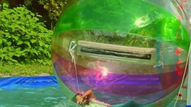 Havuzda şişme topun cazibesine kapılan kız.