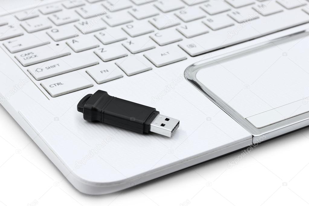 Closeup of USB Flash drive resting on laptop