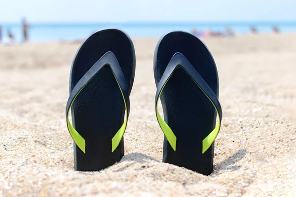 Chanclas en la playa de arena . — Foto de Stock