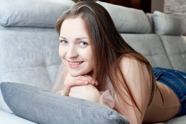 Kanepede rahatça uzanan bir kızın portreleri.