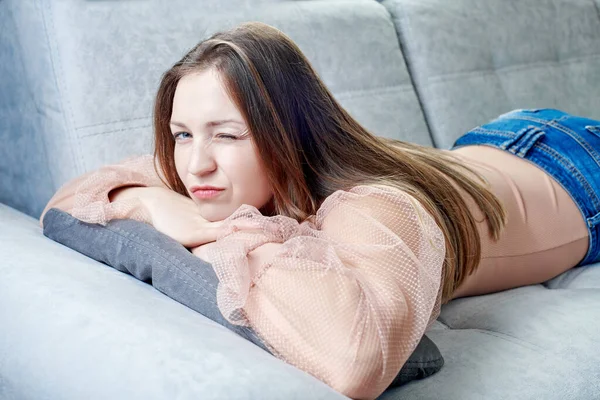 Портрети дівчини, що лежить на розслабленому дивані — стокове фото