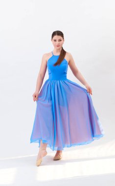 Güzel elbiseli kız stüdyoda dans ediyor.