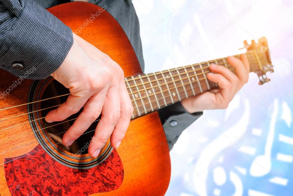 hand to pluck the strings of a guitar
