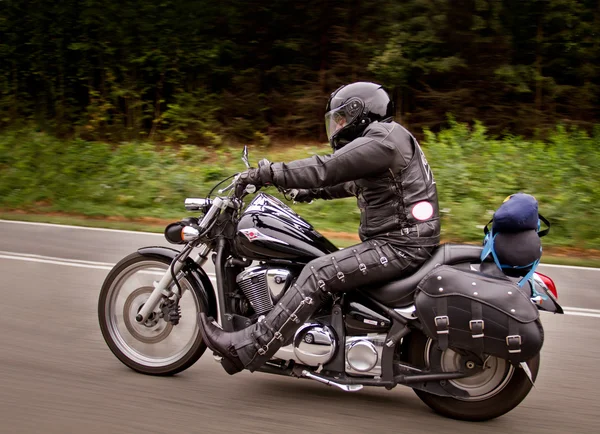 Motociclista andando rápido em sua moto. efeito de borrão de velocidade . — Fotografia de Stock