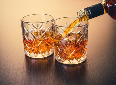 Viski şişeden bir bardağa dökülür.