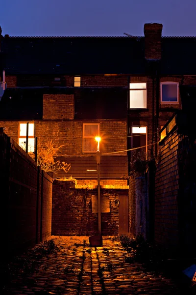 Dark inner city cobblestoned back alley with streetlight at night — Stock Photo, Image