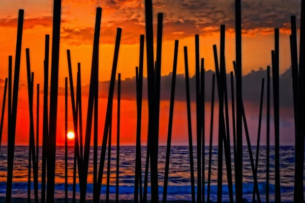 Digital painting of looking through beach umbrella poles at sunset — Stock Photo, Image