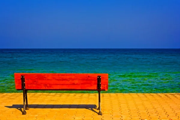 Una pintura digitalmente convertida de un banco solitario con vistas al mar — Foto de Stock