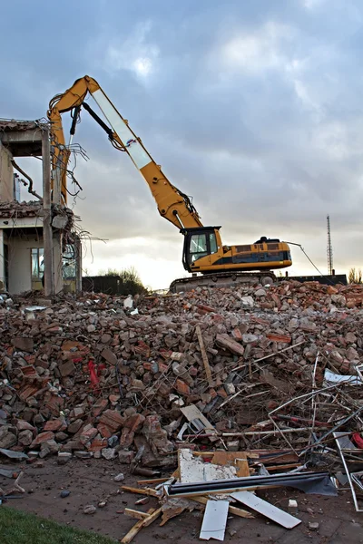 Escavadeira de canteiro de obras desmontando um edifício — Fotografia de Stock