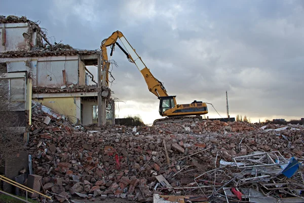 Escavadeira de canteiro de obras desmontando um edifício — Fotografia de Stock