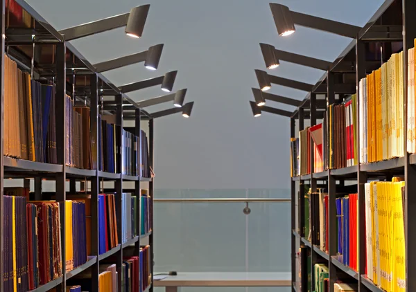 Estantes llenos de libros en una biblioteca moderna —  Fotos de Stock