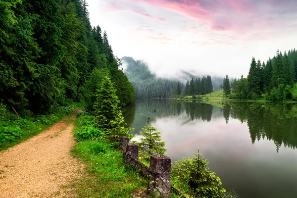 Misty amanecer con nubes en el Lago Rojo Rumania — Foto de Stock