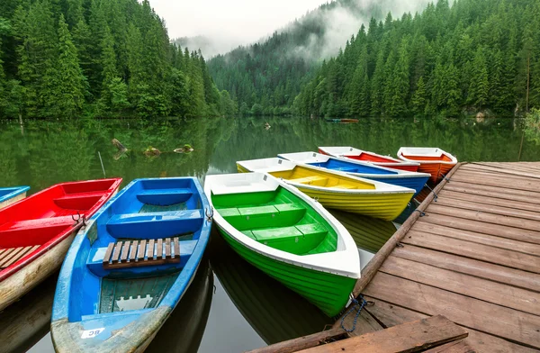 Цветные лодки пришвартованы на горном озере — стоковое фото