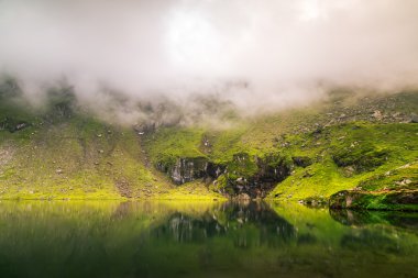 Dağ sis yansıtma gölde. Arka plan olarak yararlı.