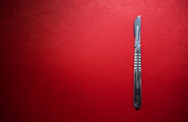 Neşter kırmızı zemin üzerine. Arka plan olarak yararlı