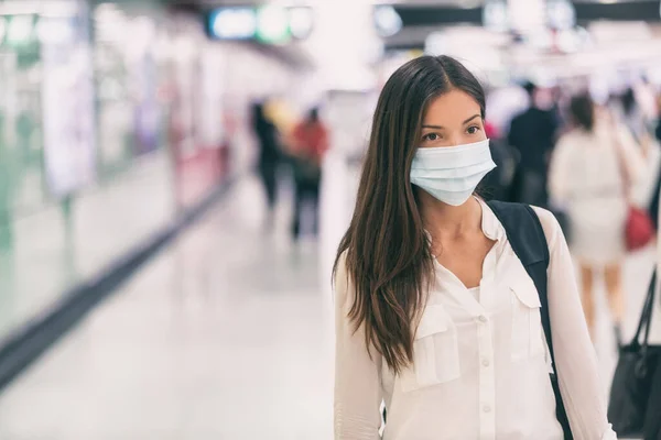 Coronavirus Asyalı kadın cerrahi maskeyle yürürken korunuyor. Havaalanı tren istasyonunda kalabalıklar arasında yürüyor. Hastaneye gidip geliyor. — Stok fotoğraf