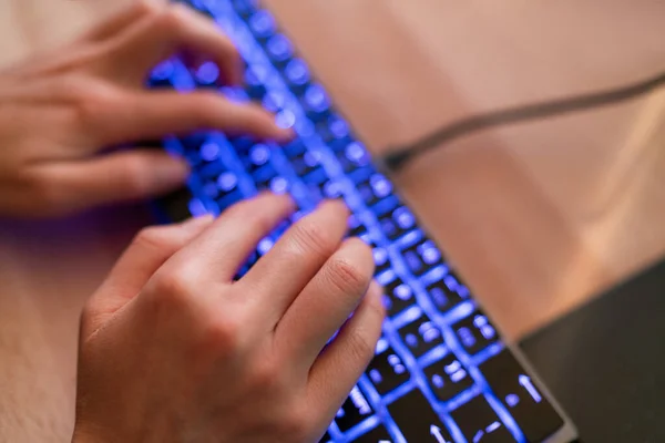 游戏玩家电脑键盘女士在蓝色背光游戏键盘上打字，深夜在家里的写字台上工作 — 图库照片