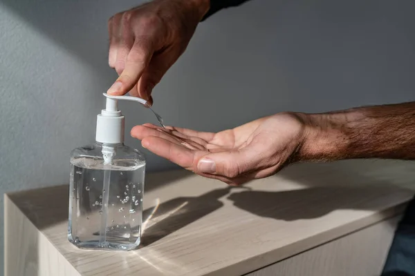 Hand sanitizer bottle man using dispenser gel rub for corona virus hands hygiene coronavirus COVID-19 pandemic prevention — Stock Photo, Image