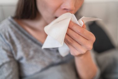Cough in tissue covering nose and mouth when coughing as COVID-19 hygiene guidelines for coronavirus spread prevention clipart